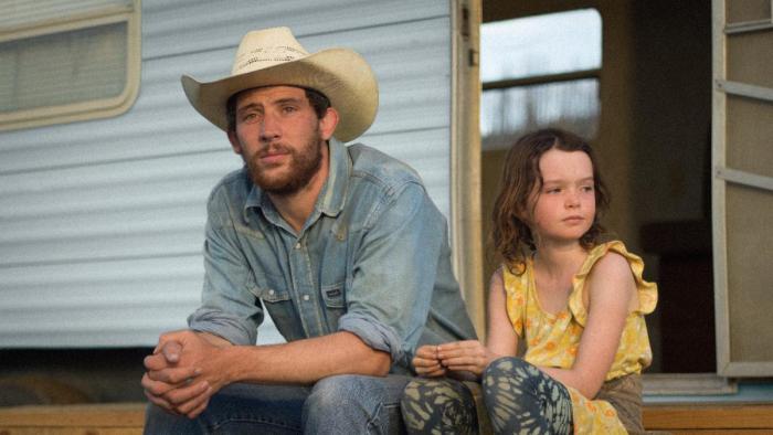 Rebuilding movie: Dusty Fraser (Josh O'Connor) sits on the steps of a mobile home next to daughter Callie Rose (Lily LaTorre) 
