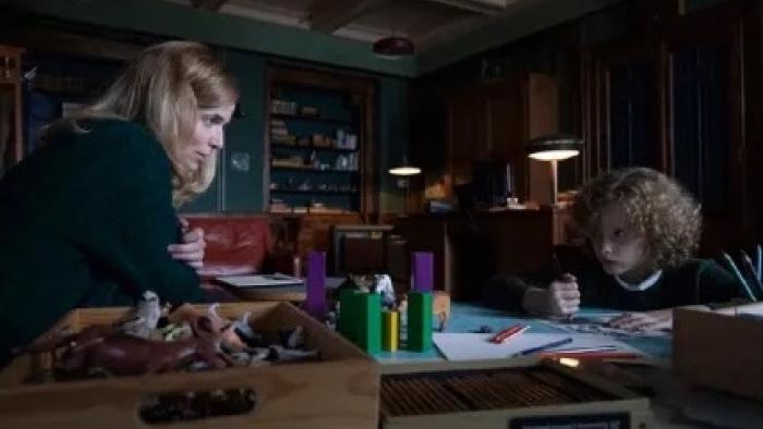 Marionette: Dr. Marianne Winter and Elijah Wolf sit at opposite sides of a desk as he draws a picture.
