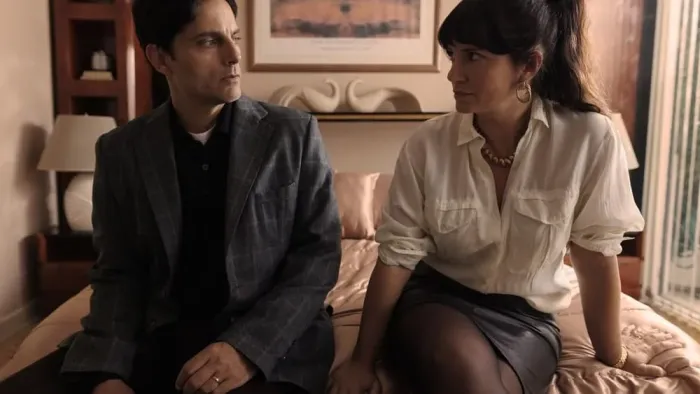 Rest in Peace movie: In bedroom an Argentinian man left sits on end of bed next to Argentinian woman right