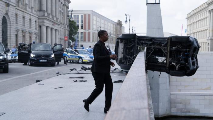 Retribution Movie: Officer Angela Brickmann (Noma Dumezweni) rushes to the side of a bridge, where a car is balanced on its side, looking like it's about to fall in the water