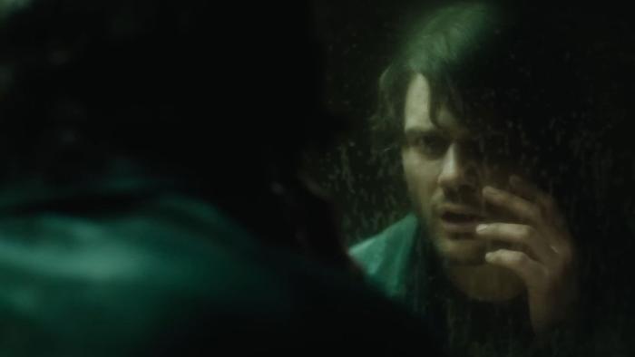 Return to Silent Hill Movie: James Sunderland (Jeremy Irvine) regards his face in a grungy mirror and touches his cheek
