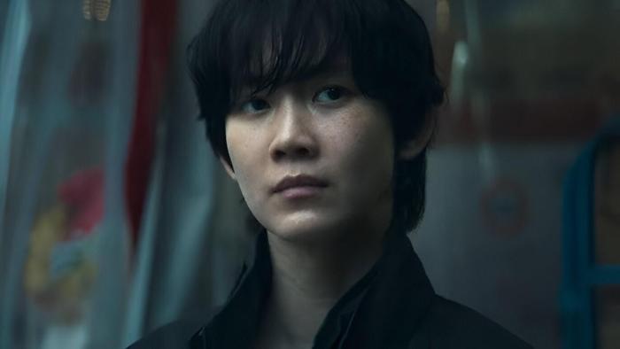 Revelations movie: Korean woman with short black hair in black denim jacket center looks to the side
