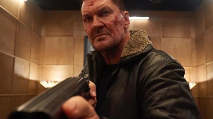Vengeance -- Rise of the Footsoldier: Craig Fairbrass with a bloody face holds a shotgun.