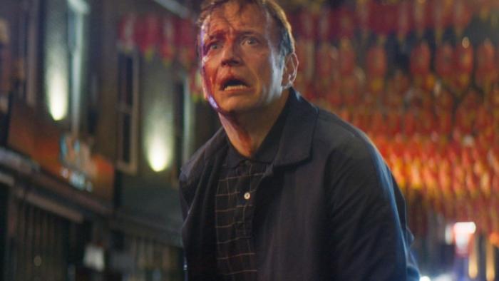 Vengeance -- Rise of the Footsoldier: A White man with bloody injuries on his face stands in a London street at night.