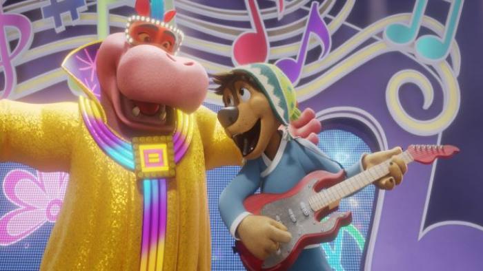 A hippo and Rock dog stand next to eachother singing with a colorful background with music notes