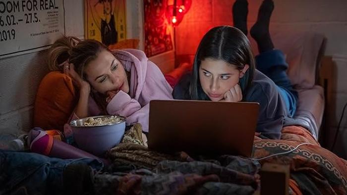 Roommates: Chloe East and Sadie Sandler watch TV.