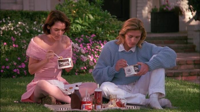 Welcome Home, Roxy Carmichael: A teenage girl and boy having a picnic on grass, surrounded by flowers