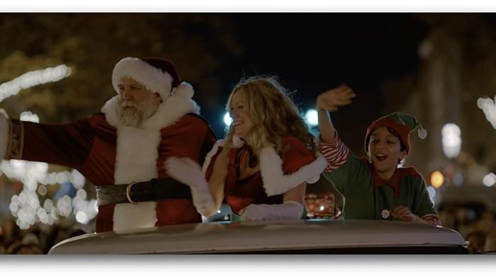 Saint Nick of Bethlehem movie: Daniel Roebuck, Marsha Dietlein, and Elias Kemuel on the back of a truck, waving to people at night