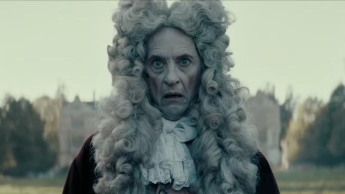 Savage House: Richard E. Grant wears a large, Elizabethan-era wig and a ghostly expression on his face