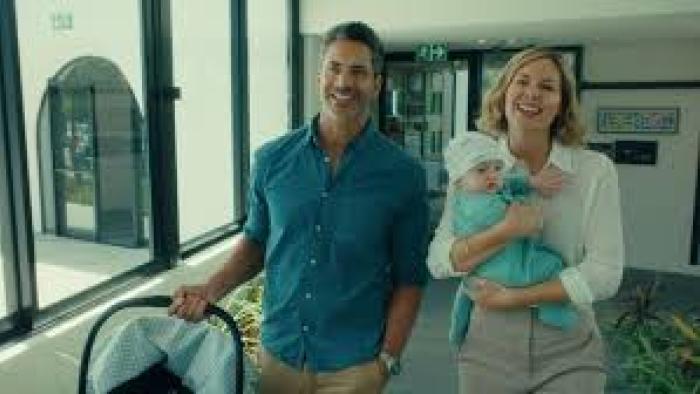 Semi-Soeter: Smiling couple walk with baby