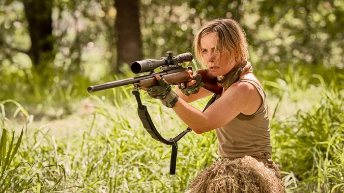 Seven Snipers: Woman aiming a rifle in grassy field