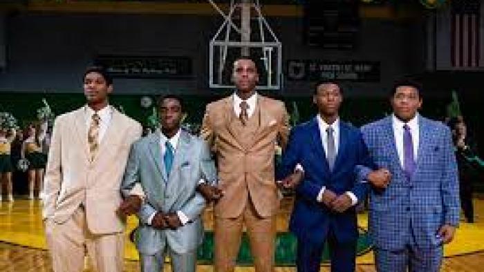 Shooting Stars scene 1: 5 Black basketball players stand in suits on the court