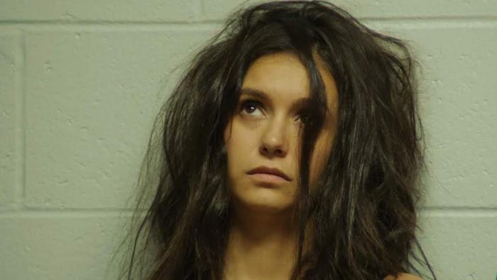 Sick Girl Movie: Wren leans against the cinderblock wall of a jail