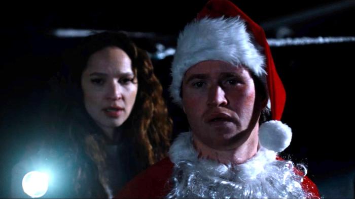 Silent Night, Deadly Night Movie: Pam (Ruby Modine) holds a flashlight as Billy (Rohan Campbell) regards the situation