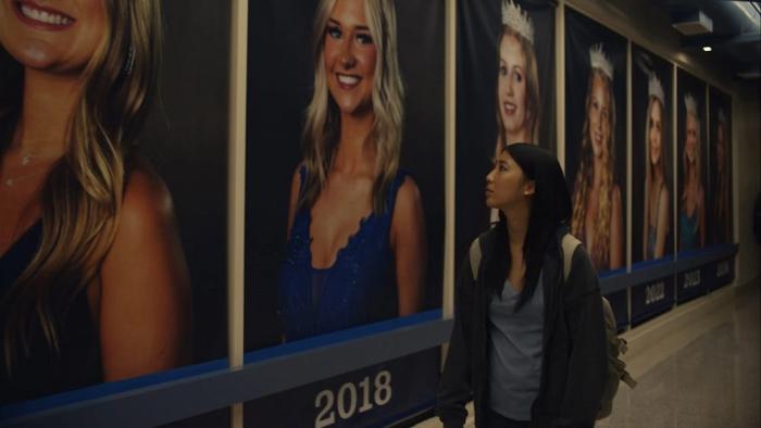 Slanted movie: Shirley Chen walks down a hallway that's lined with past prom queens
