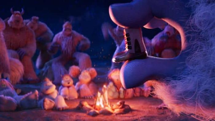 Smallfoot movie: A group of yetis sits around a fire looking at a tiny boot