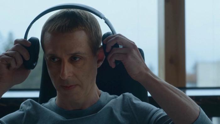 The Social Reckoning movie: Mark Zuckerberg (Jeremy Strong) puts headphones on