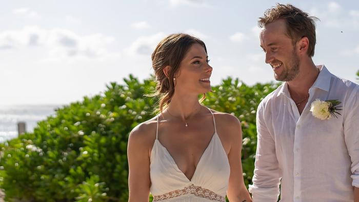 Some Other Woman: Ashley Greene and Tom Felton smile at each other with coastal landscape behind them
