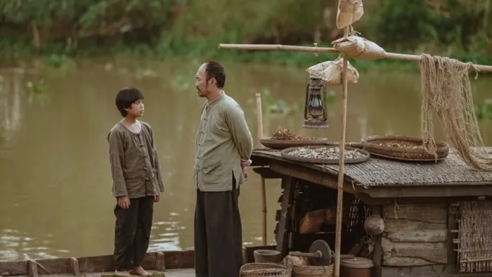 Song of the South: Huynh Hao Khang talks with a man by a boat.