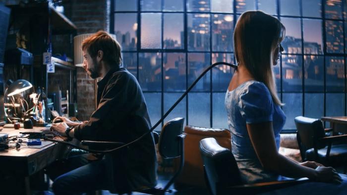 Soulm8te movie: David works at a keyboard while a cable is connected to the back of Sara's neck