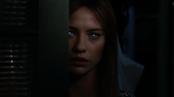 Soulm8te movie: Sara, with sinister, glowing eyes, peeks out from behind a doorway