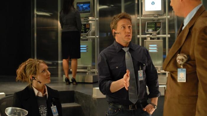 Space Buddies movie: Three adults talk to one another inside a Mission Control-type room