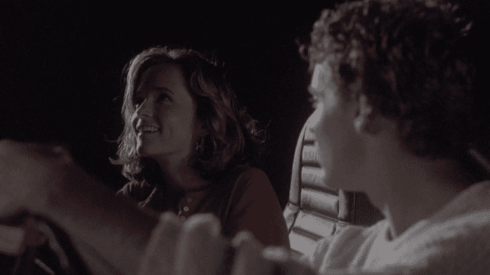 SpaceCamp movie: Two people sit in a car at night, smiling and talking.