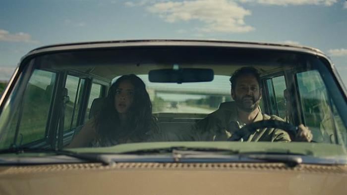 Splitsville Movie: In their car, Ashley (Adria Arjona) and Carey (Kyle Marvin) see something shocking while on the road