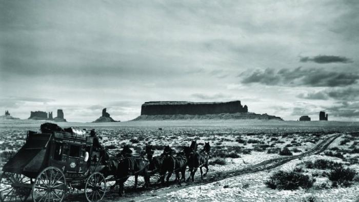 Stagecoach movie: A stagecoach pulled by several horses in black-and-white against a desert landscape