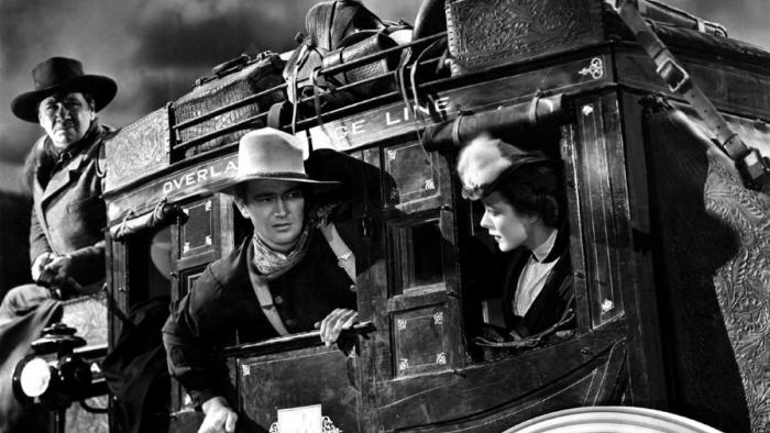 Stagecoach movie: Three adults lean about of a stagecoach