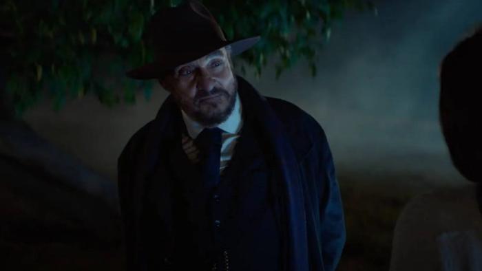 Starbright movie: John Rhys-Davies stands in the dark wearing a suit and hat