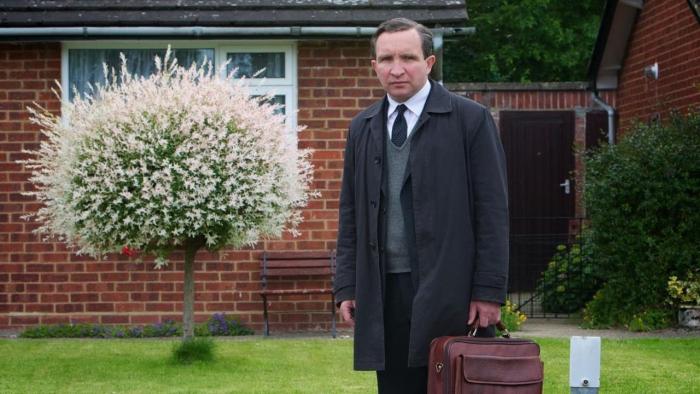 Still Life: Eddie Marsan looks serious as he holds a briefcase outside someone's house