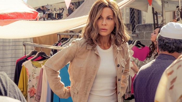 Stolen Girl movie: Kate Beckinsale stands, hands on hips, among racks of clothes