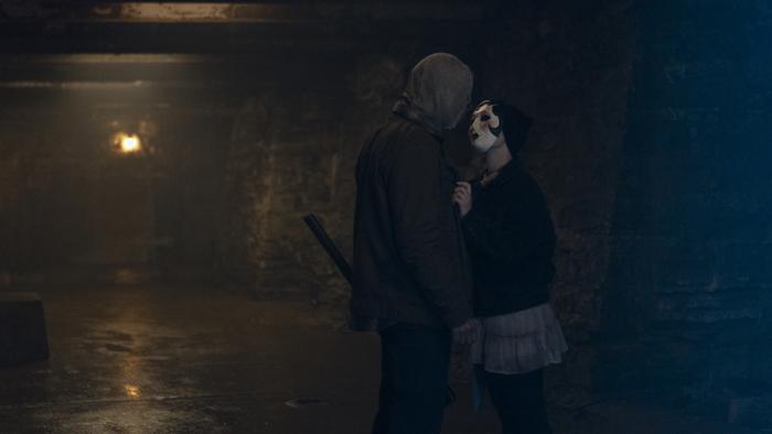 The Strangers: Chapter 3 Movie: "Scarecrow," holding an axe, and "Pin-Up Girl" get close together after a killing