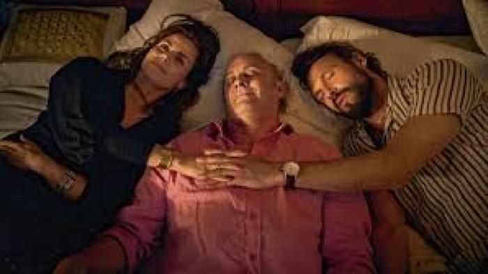 Stromboli: three clothed people lie in a bed together to comfort each other