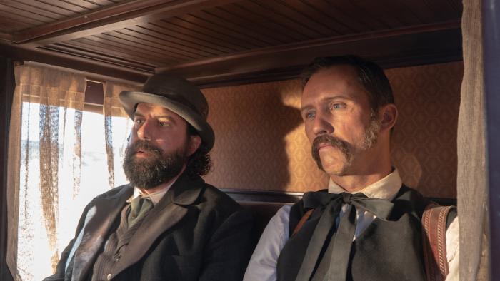 Surrounded Movie: Fields (Brett Gelman, left) and Wheeler (Jeffrey Donovan) ride on the stagecoach