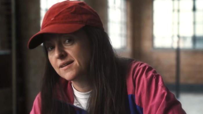 Swede Caroline: Jo Hartley wears a baseball cap and tracksuit top, looking to camera as she's interviewed