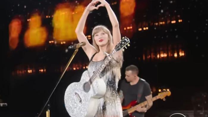 Taylor Swift: The Eras Tour –  The Final Show: Swift sings with a guitar.