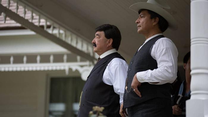 Te Ata Movie: Two adult Native men stand side-by-side wearing waistcoats and white long-sleeves