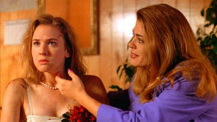 Texas Chainsaw Massacre—The New Generation: A woman leans over and touches the side of a frightened woman’s face