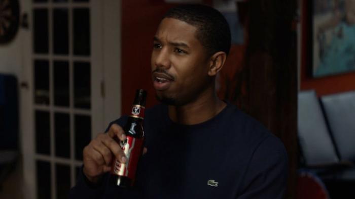That Awkward Moment Movie: Michael B. Jordan holds a Tecate beer bottle while talking indoors