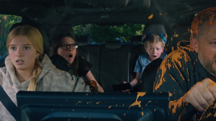 The Breadwinner movie: Nate Bargatze reacts with disgusted surprise while being splashed in orange goo while driving his three daughters