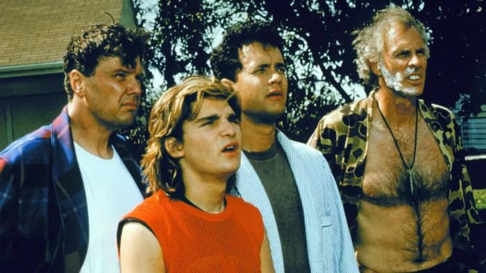 The 'Burbs Movie: A group of men stand outside a suburban house and look towards the same thing