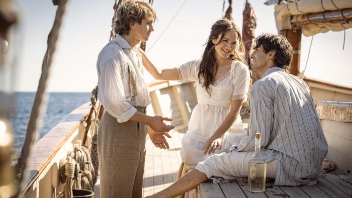 The Count of Monte Cristo (2024) movie: Fernand, Mercedes, and Edmond Dantes smile together while sailing
