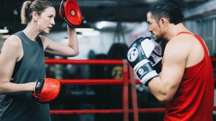 The Cut: A female boxing trainer and and a male boxer train in a boxing ring