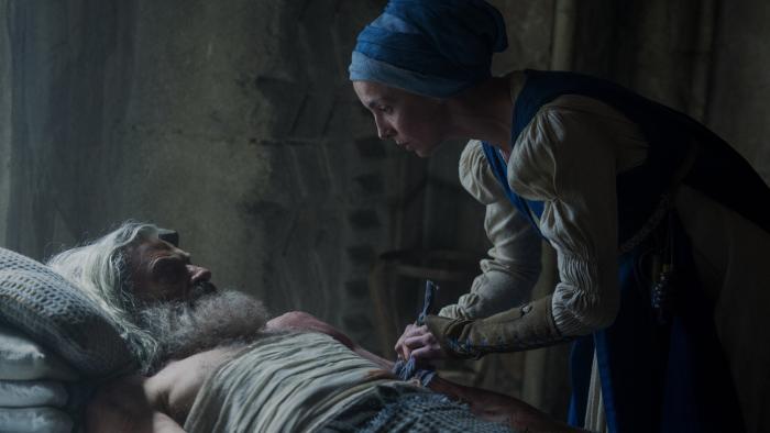 The Death of Robin Hood movie: Sister Brigid (Jodie Comer) leans over Robin Hood (Hugh Jackman) while bandaging his wounds