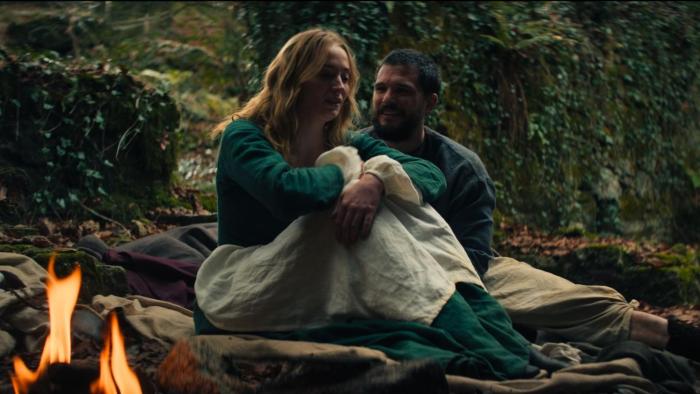 The Dreadful: Sophie Turner and Kit Harington sit together outside on blankets, with a fire burning beside them