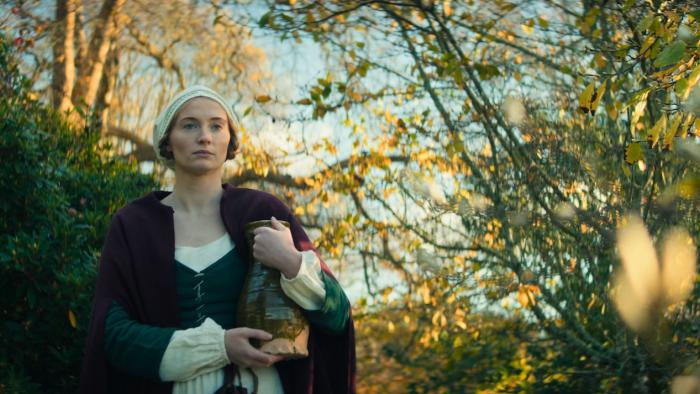 The Dreadful: Sophie Turner walks through the woods carrying water in a ceramic vessel
