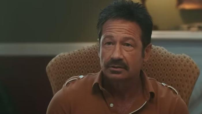 The Estate: David Duchovny sits on a mustard-coloured chair wearing a similarly coloured top.