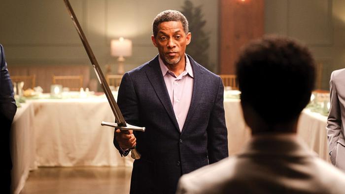 The Forge movie: Cameron Arnett holds up a sword to symbolize faith while facing his mentee, Aspen Kennedy